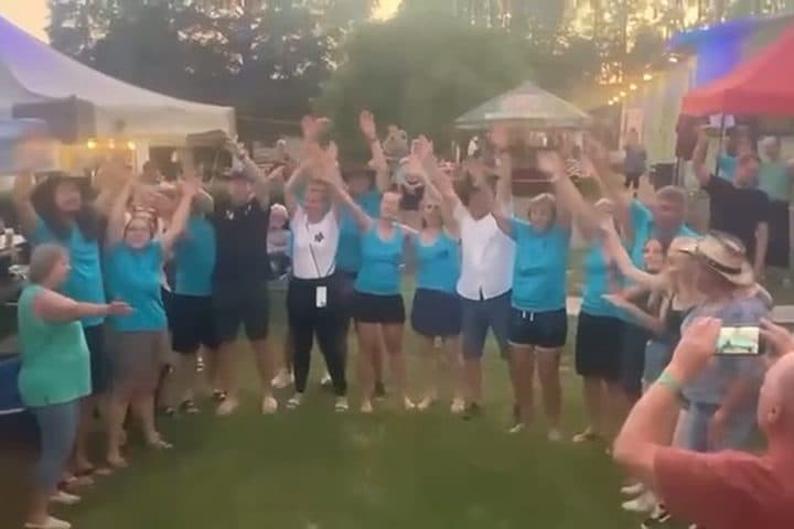 Skupina návštěvníků tleská u pódia