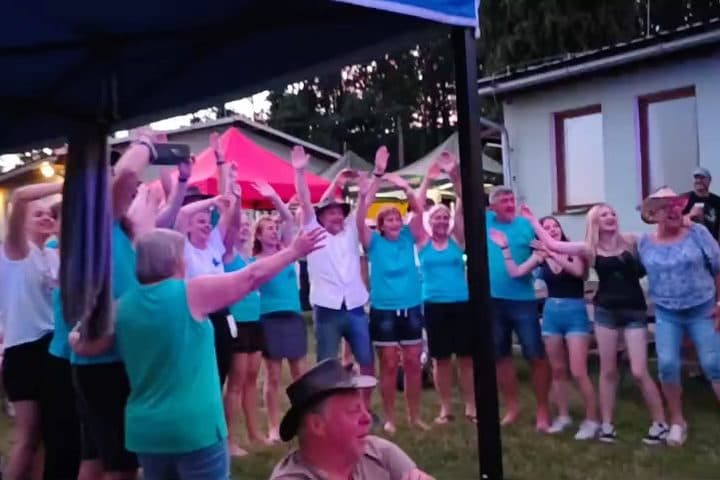 Publikum se zvednutýma rukama u pódia
